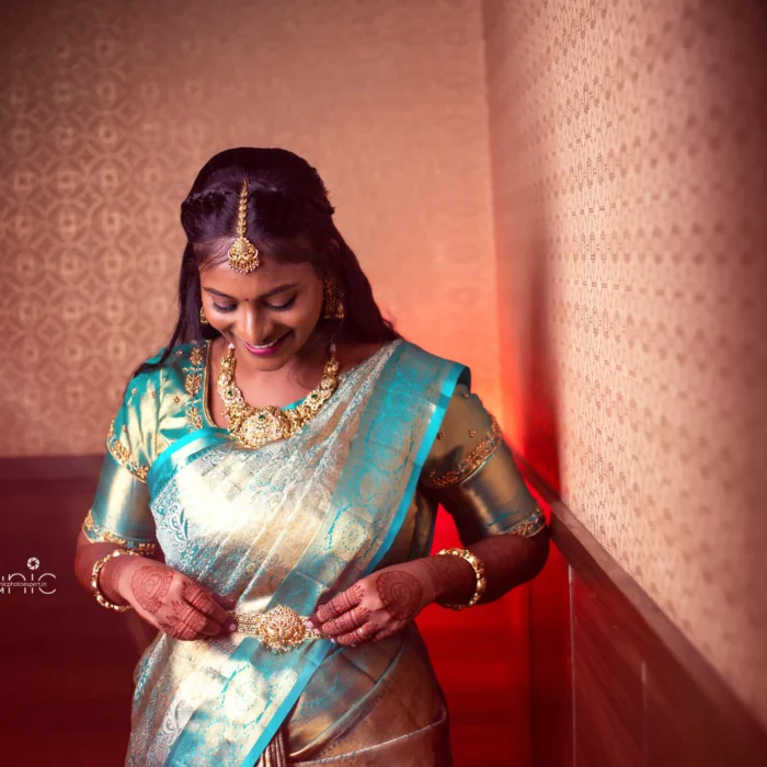 bridal photography poses 19 Elegant South Indian bride adjusting hip belt in teal Kanchipuram silk saree Erode Tamil Nadu
